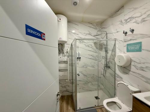 a bathroom with a glass shower and a toilet at Palomeras, Habitación de Ensueño in Madrid