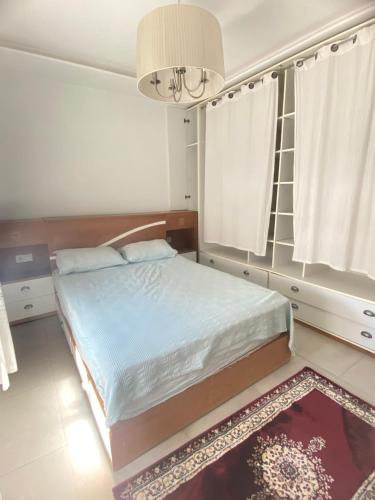 a bedroom with a bed and a chandelier at Modern & Spacious 2BR- Ville Haute Kenitra-Garage in Kenitra