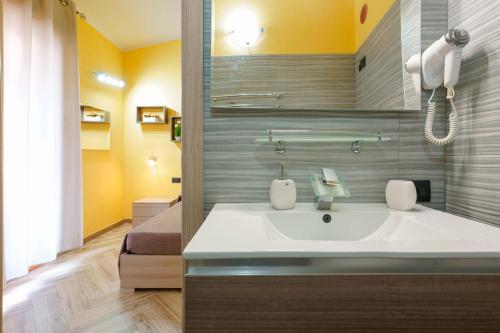 a bathroom with a sink and a bed at Paradise Home in Quartu SantʼElena