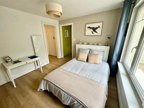 une chambre avec un lit, une table et une fenêtre dans l'établissement La Petite Boulonnaise Studio cosy avec cour privative - proche Nausicaa, à Boulogne-sur-Mer