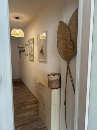 un couloir avec une commode et un chapeau au mur dans l'établissement Appartement plage des mouettes, à Saint-Hilaire-de-Riez