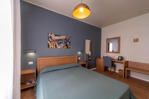 een slaapkamer met een bed, een tafel en een bureau bij A Due Passi dal Mare Stanza N2 in Porto Ercole