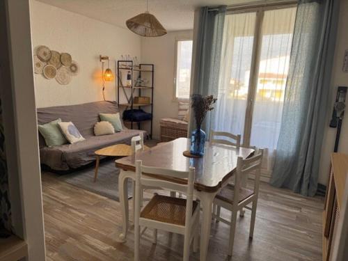 un salon avec une table et un canapé dans l'établissement Appartement plage des mouettes, à Saint-Hilaire-de-Riez