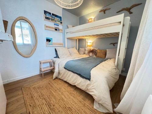 une chambre avec un grand lit et un miroir dans l'établissement Appartement plage des mouettes, à Saint-Hilaire-de-Riez