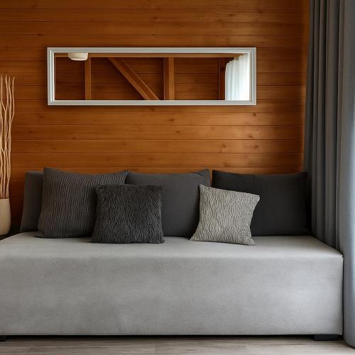 a couch with three pillows on it in a room at Resort EDEN - domki, pokoje, apartamenty, sauna, jacuzzi in Jastrzębia Góra