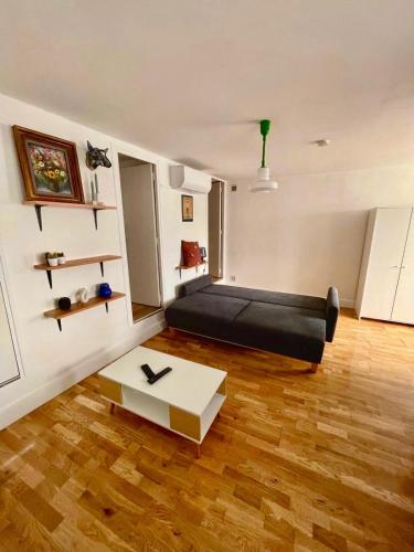 - un salon avec un lit noir et une table dans l'établissement Large 2-Room Air-Conditioned with Terrace - Near Train Station, à Toulouse