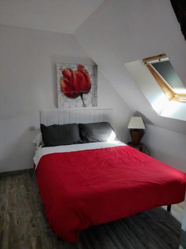 Ce lit rouge se trouve dans une chambre blanche dotée d'une fenêtre. dans l'établissement La forge, à Le Quiou