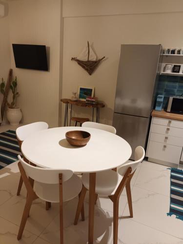 a kitchen with a white table and white chairs at Β&Κ home in Kalamata