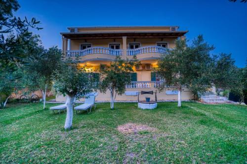 a large house with trees in front of it at Stefanias Prasoudi Beach in Ágios Matthaíos