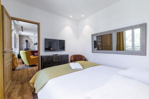 une chambre blanche avec un lit et un miroir dans l'établissement Appartement Maison Cannes, à Cannes