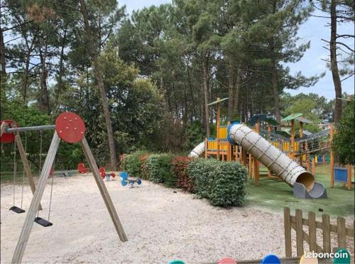 ein Park mit einem Spielplatz mit Rutsche in der Unterkunft T2 32m2 terrasse 8m2 PISCINE LACANAU OCEAN LAC GOLF MULTISPORT in Lacanau-Océan