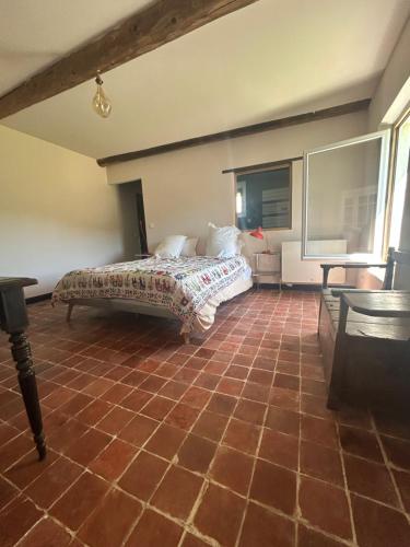 a bedroom with a bed and a tiled floor at Silence et Reconnexion in Mormoiron