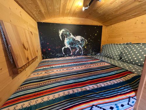 - un lit avec une peinture murale représentant un cheval dans l'établissement Les Roulottes de Camarkas, à Saintes-Maries-de-la-Mer