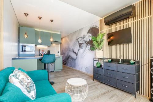 un salon avec un canapé bleu et une cuisine dans l'établissement Emeraude Port Nature, au Cap d'Agde