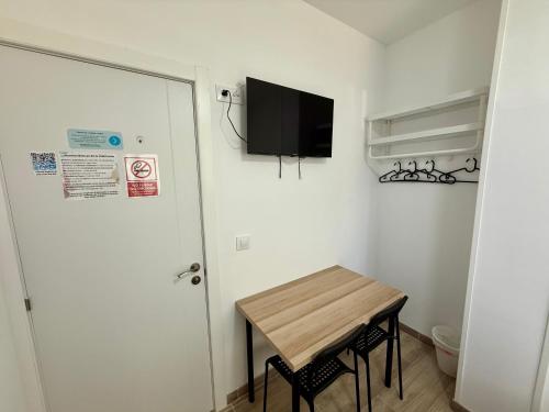 a small room with a table and a tv on the wall at Palomeras, Habitación de Ensueño in Madrid
