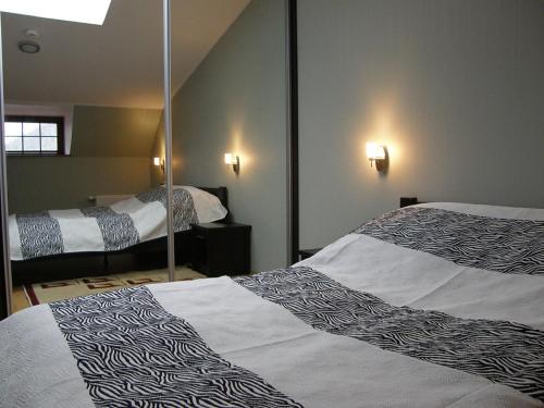 a hotel room with two beds and a mirror at Apartament 42 Loft - Pod Aniołem in Kazimierz Dolny