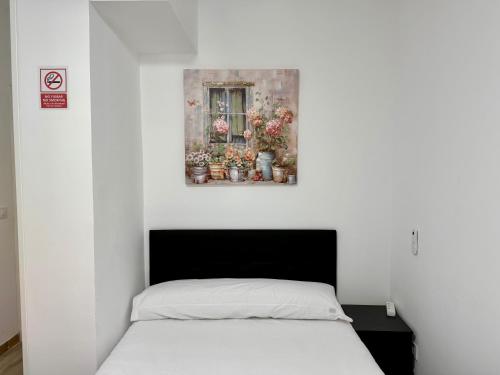 a bedroom with a bed and a window with flowers at Palomeras, Habitación de Ensueño in Madrid