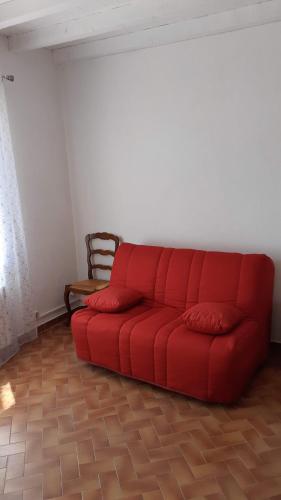 - un canapé rouge dans une pièce avec une chaise dans l'établissement Studio a la campagne, à Châteauneuf-du-Pape