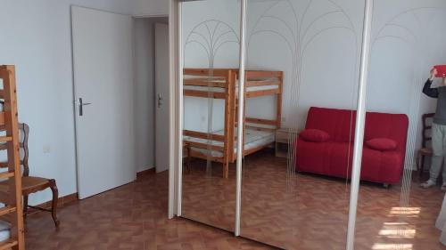 Cette chambre comprend des lits superposés et un canapé rouge. dans l'établissement Studio a la campagne, à Châteauneuf-du-Pape