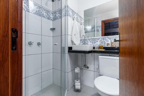 Un baño con inodoro, lavabo y espejo. en Casa Apartamento Salzburgo by Achei Gramado, en Gramado