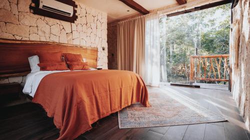 Un dormitorio con una cama y una ventana grande. en Tulum Jungle Villa Fuego, en Chemuyil