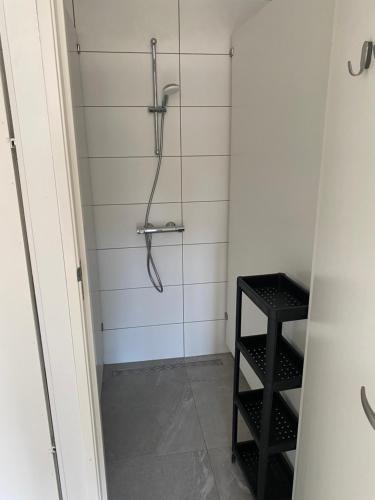 a shower in a bathroom with a black stool at Luxe Glamping tent met sterrenhemel in Rijsenhout