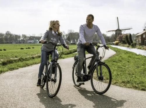 a man and a woman riding bikes down a road at Luxe Glamping tent met sterrenhemel in Rijsenhout