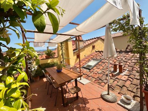 a patio with a table and an umbrella at La terrazza di Sofia in Lucca