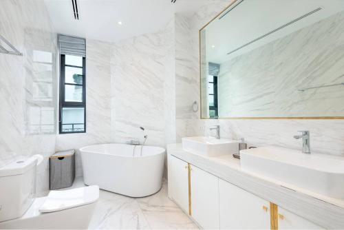 a bathroom with two sinks and a large mirror at Stylish 7Beds Poolhouse with Cinema Lift - 2min to BTS in Amphoe Phra Khanong