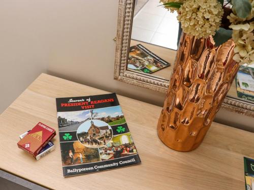 a book sitting on a table next to a vase at Daly's Back House in Clogheen