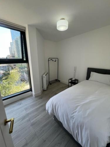 a bedroom with a white bed and a large window at Alhambra House, Modern 2 Bed Flat - F2 in Croydon
