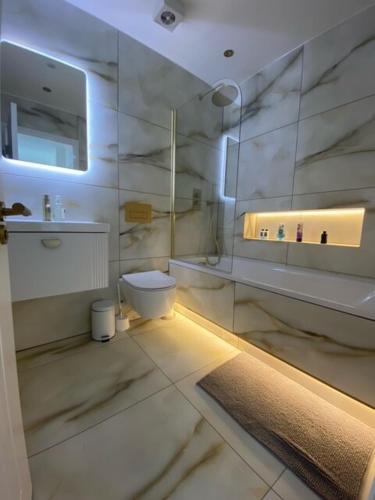 a white bathroom with a toilet and a sink at Alhambra House, Modern 2 Bed Flat - F2 in Croydon