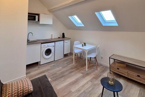 une cuisine et un salon avec une table et un évier dans l'établissement Le Studio des Parcs, à Amiens