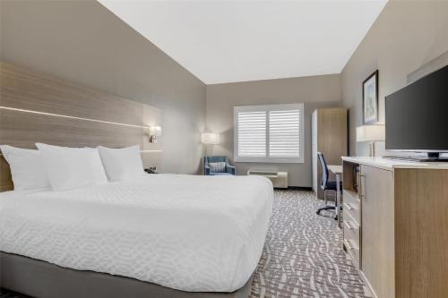 a hotel room with a bed and a flat screen tv at Best Western Plus Lake Elsinore Inn & Suites in Lake Elsinore
