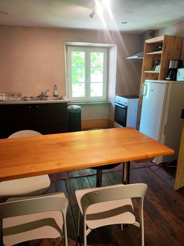 une cuisine avec une table et des chaises en bois dans l'établissement La Demeure des Forges, à Grandfontaine