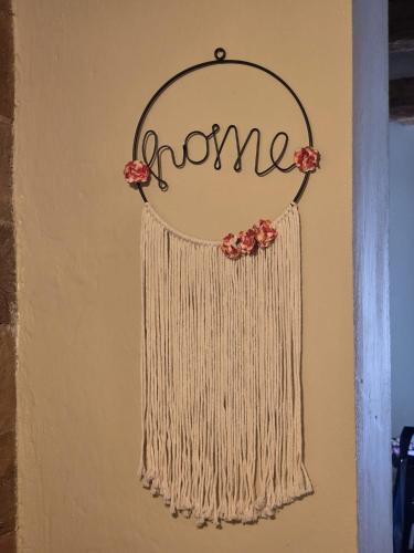a wall with a hanger with the word home at Casa Olivia in Castelfiorentino