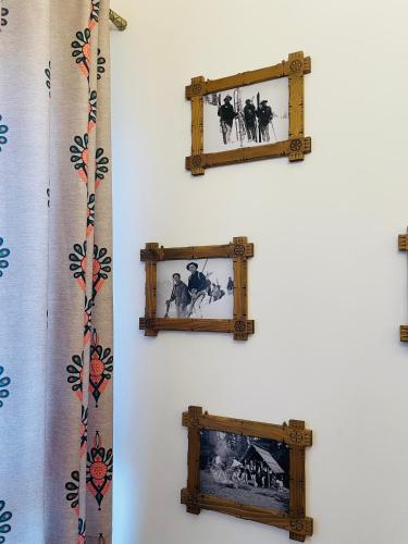 two pictures in wooden frames on a wall at Wystrugane Apartamenty in Białka Tatrzanska