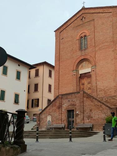 a man walking in front of a brick building at Casa Olivia in Castelfiorentino