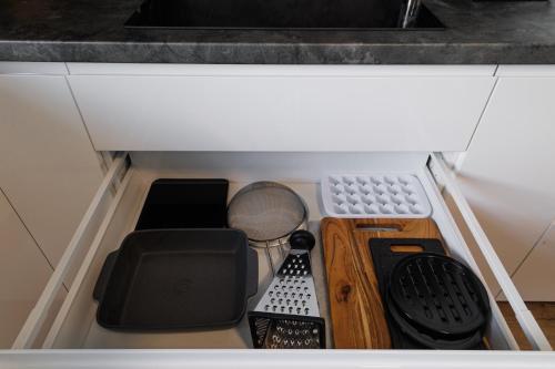 a drawer in a kitchen with various items in it at Pool Villa Mukařov in Srbín