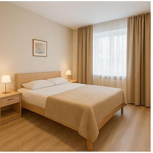 een slaapkamer met een groot bed en een raam bij Hostel Harmony in Zhezdi