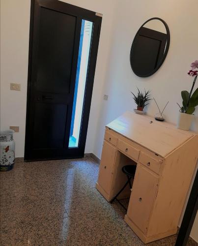 a wooden desk with a mirror next to a door at Aromatika, b&b, affittacamere in Faenza