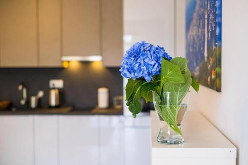 a vase filled with blue flowers sitting on a counter at Füred Luxury Apartman with private pool in Balatonfüred