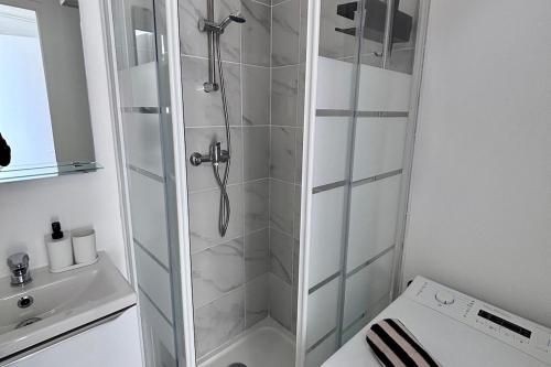 une douche avec une porte vitrée dans une salle de bain dans l'établissement Studio Greenway, à Amiens