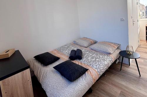 - une chambre avec un lit avec des oreillers et une table dans l'établissement Studio Greenway, à Amiens