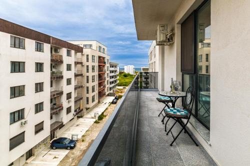 ナボダリにあるLago Retreat Apartamentの建物の上にテーブルと椅子が置かれたバルコニー