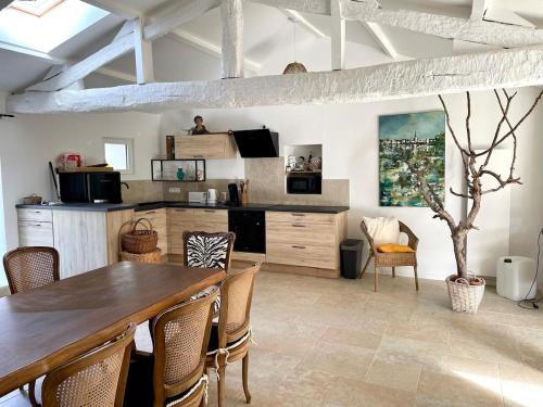 une salle à manger avec une table et des chaises en bois dans l'établissement Gite de charme trois chambres au pied des marais grand jardin, à LʼÎle-dʼOlonne
