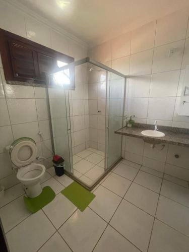 a bathroom with a shower and a toilet and a sink at Duplex à 800 mts do Beach Park COM 5 suítes in Aquiraz