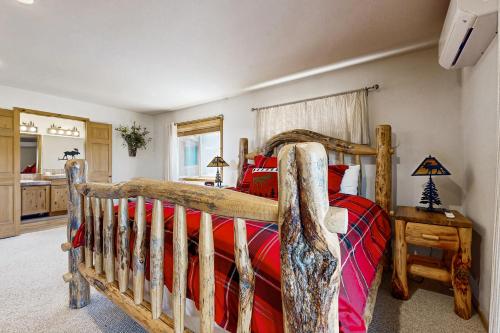 1 dormitorio con cama de madera y almohadas rojas en Cedar Lane Getaway, en McCall