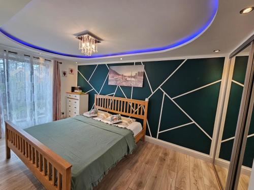 a bedroom with a bed and a green wall at Allan & Ella House in Perth