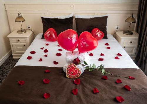 a bed with red hearts and balloons on it at Casa del Monte - Dorna Arini in Dorna Arini